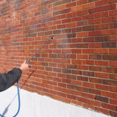 Deco 20 Clear a man spraying solution on a brick wall
