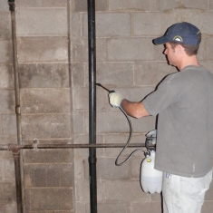 Deco Healthy Walls A man spraying solution on a brick wall