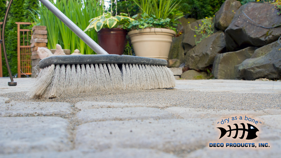 A close up image of a broom sweeping dirt